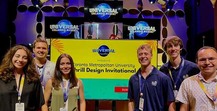 group of students, smiling in front of banner