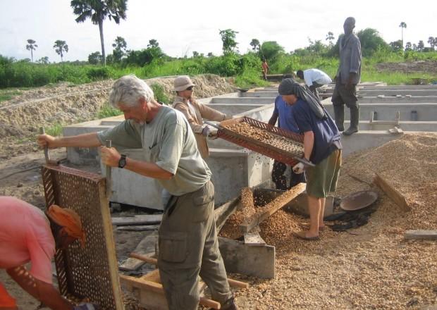 Volunteers with the UA chapter of Engineers Without Borders assist villagers in Ghana with rock sieves to help filter water.