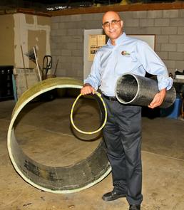QuakeWrap president Mo Ehsani, professor emeritus of civil engineering at the UA, demonstrates carbon laminate honeycomb pipe sections of various sizes built at his facility in Tucson, Ariz.